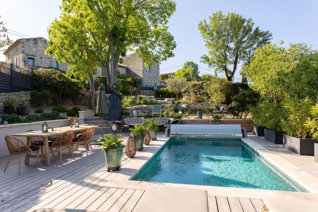 a backyard with a swimming pool and a table and chairs at MAISON BELLEVUE DE SAGRIES in Sagriès