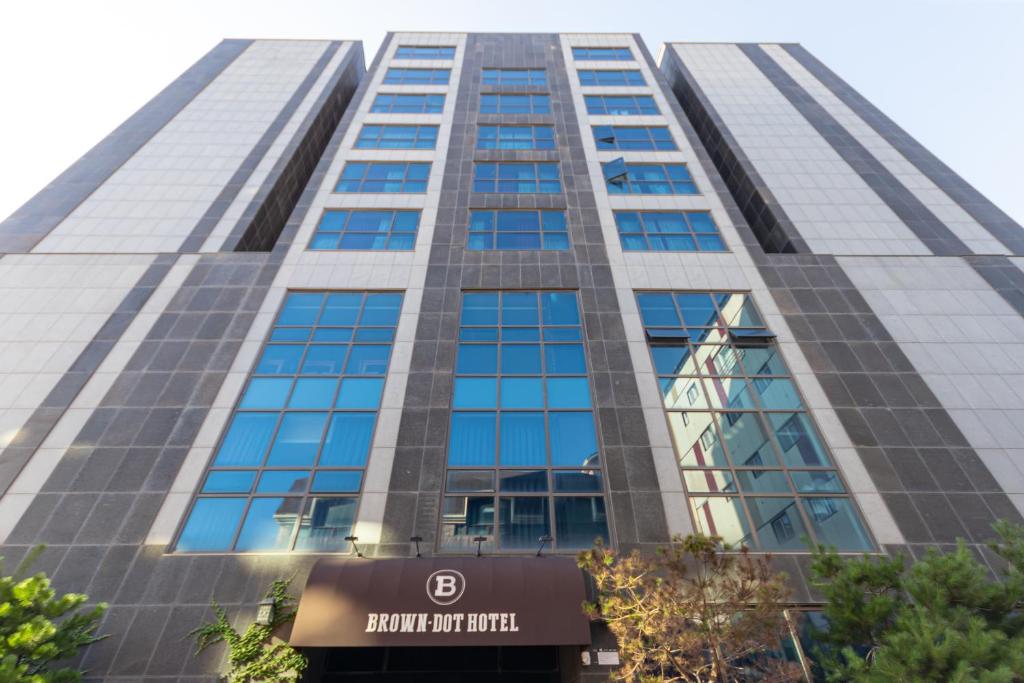een hoog gebouw met een bord ervoor bij Browndot Hotel Incheon Songdo in Incheon