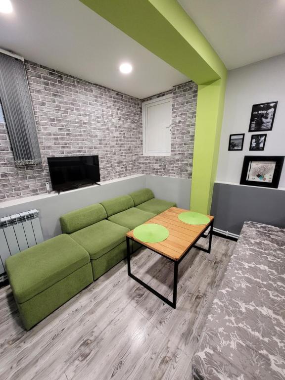 a living room with a green couch and a table at Дом 33 возле клиники Астхик in Yerevan
