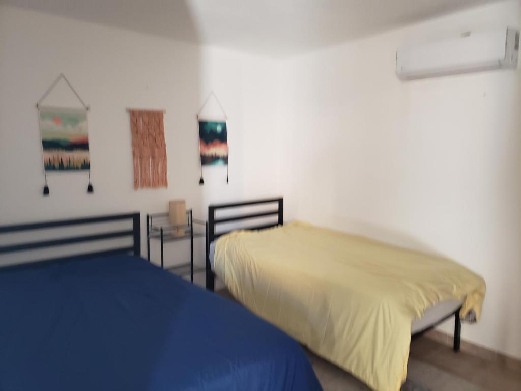 a bedroom with two beds with yellow and blue sheets at Baja's Rest Stop in San Felipe