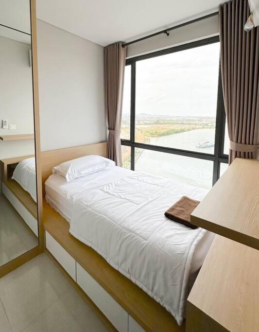 a bedroom with a bed and a large window at One Residence Apartment 2BR near Ferry Terminal in Batam Center