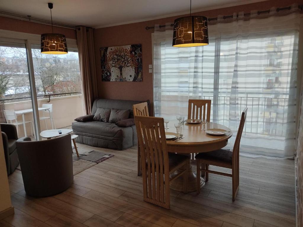 uma sala de estar com uma mesa e cadeiras e um sofá em Charmant appartement au bord du Thiou - Annecy em Annecy