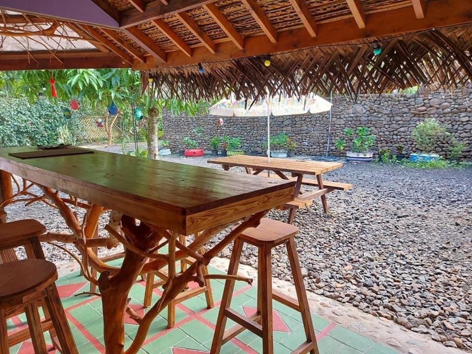 a group of picnic tables under a straw roof at Moorea Vaiare Lodge in Moorea
