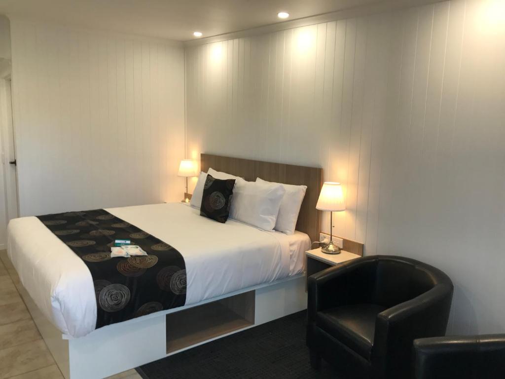 una camera d'albergo con letto e sedia di Room Motel Kingaroy East a Kingaroy