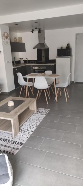 een keuken en eetkamer met een tafel en stoelen bij Lilas in Giromagny