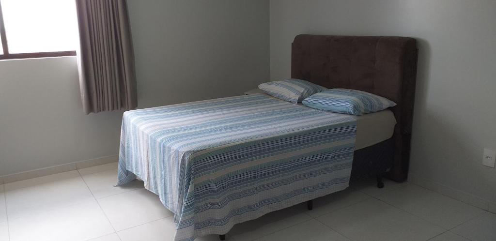 Cama pequeña con manta a rayas y 2 almohadas en Maravilhoso Home Service(502)prox Shopping Partage en Campina Grande