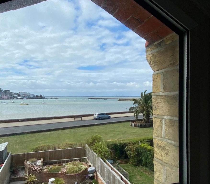 a view of the ocean from a window at Cozy coastguard cottage with sea views in East Cowes