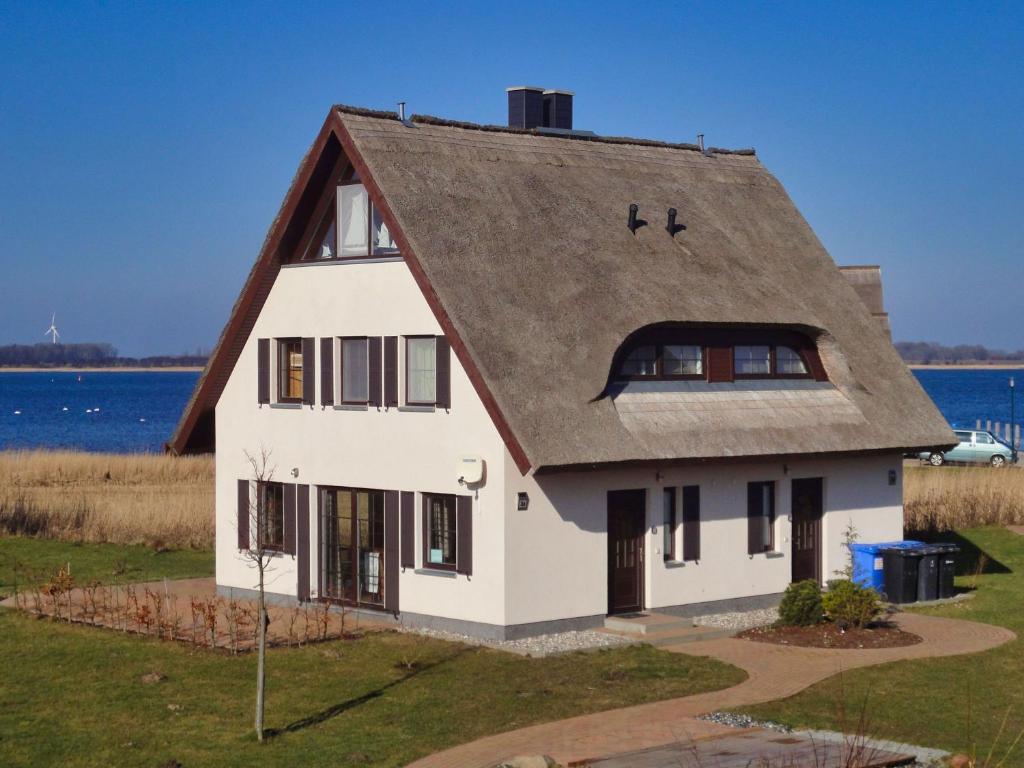a white house with a gambrel roof at idyllisches Ferienhaus mit eigener Sauna, Kamin und Terrasse - Haus Kranich in Vieregge