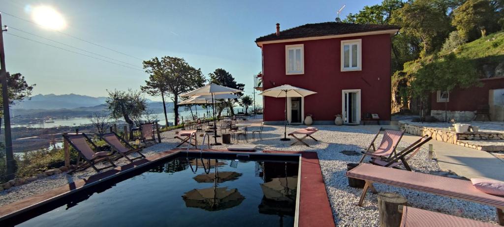 uma casa com uma piscina com cadeiras e uma mesa em Agriturismo Belvedere 9 em La Spezia