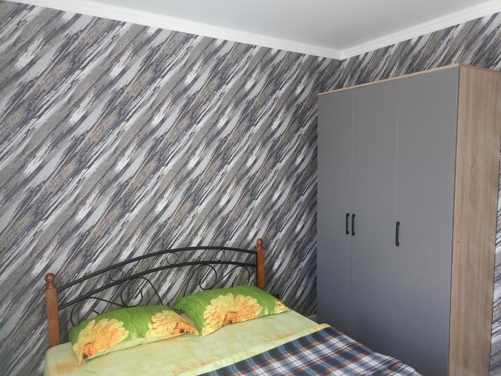 ein Schlafzimmer mit einem Bett mit einer sterngemusterten Wand in der Unterkunft Двухкомнатная квартира in Promyshlennyy