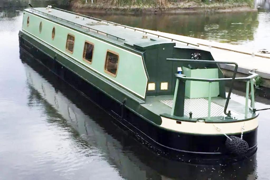 a small boat is docked in the water at Waterbeach Boatel in Cambridge