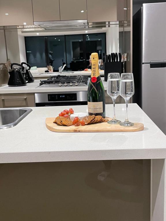 Hotel Fantastic 3 Bedroom Apartment in Southbank, a bottle of wine and two wine glasses on a counter at Fantastic 3 Bedroom Apartment in Southbank in Melbourne