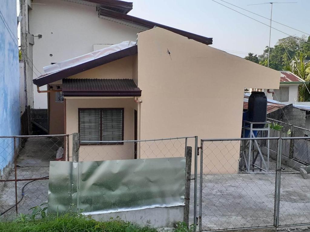 une maison avec une clôture devant elle dans l'établissement Haira Traveller's Home, à Iligan