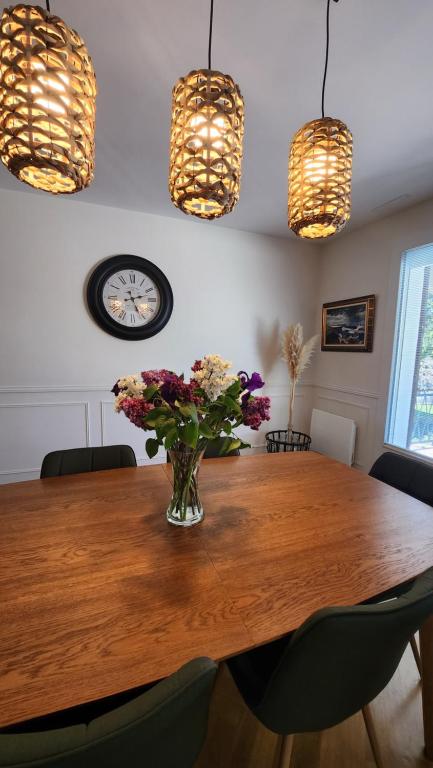 a dining room table with a vase of flowers on it at Le gîte du peintre in Entrains-sur-Nohain