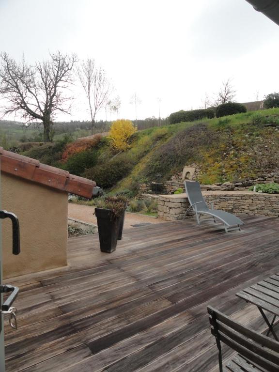 a deck with a chair and a bench on it at Les chambres de Blanot in Blanot