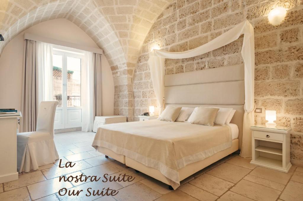 una camera con letto e parete in pietra di Hotel L'Arcangelo - Boutique Hotel a Taranto