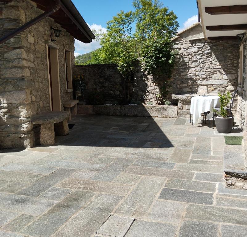 a patio with a table and a stone building at Casa Elisa affittacamere in Armeno