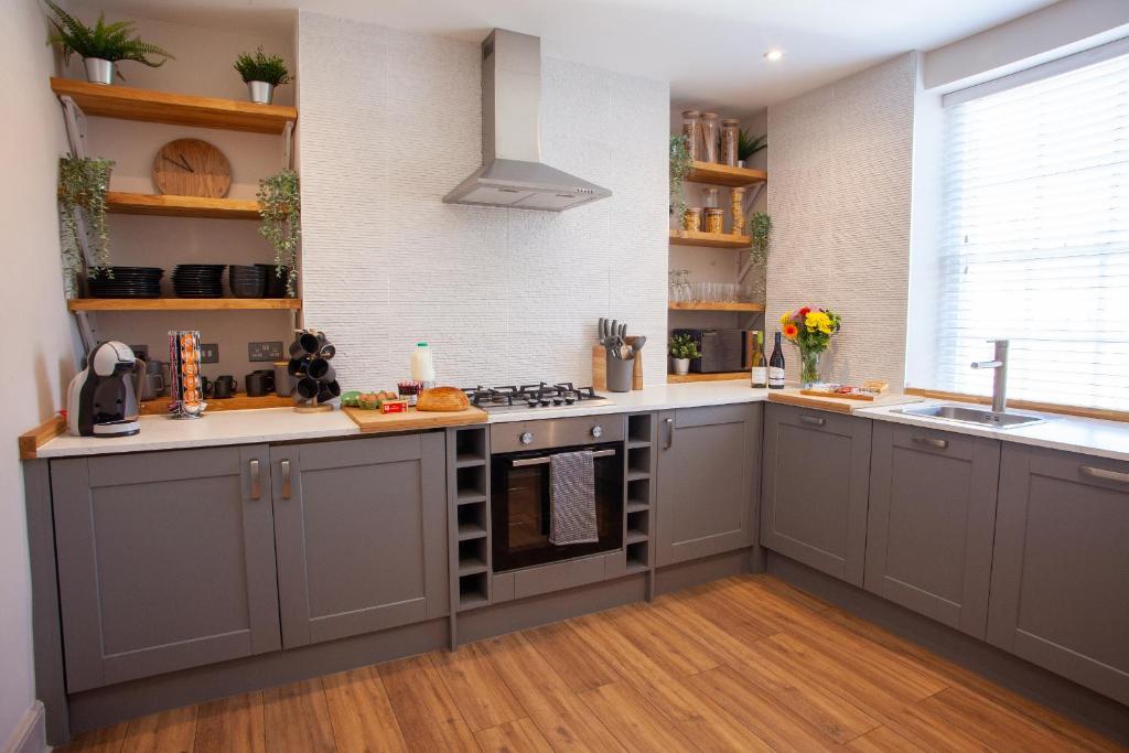 a kitchen with gray cabinets and a sink at Oxford Street Grand Apartment in Southampton