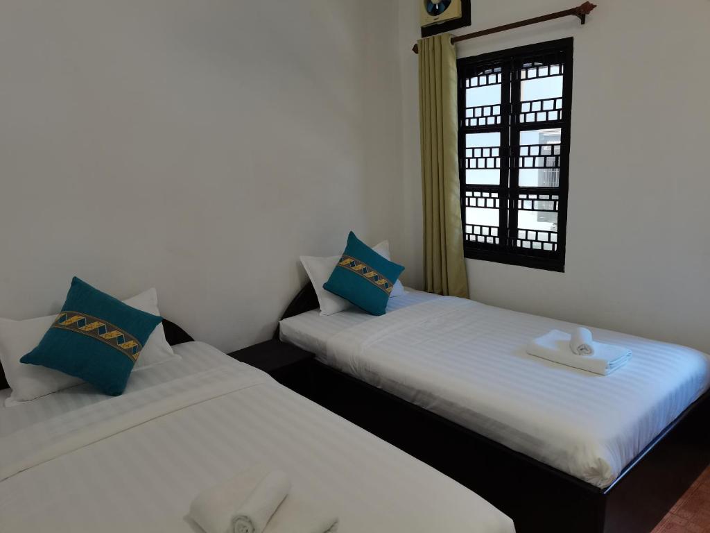 2 Betten nebeneinander in einem Zimmer in der Unterkunft PHAI GUESTHOUSE in Luang Prabang