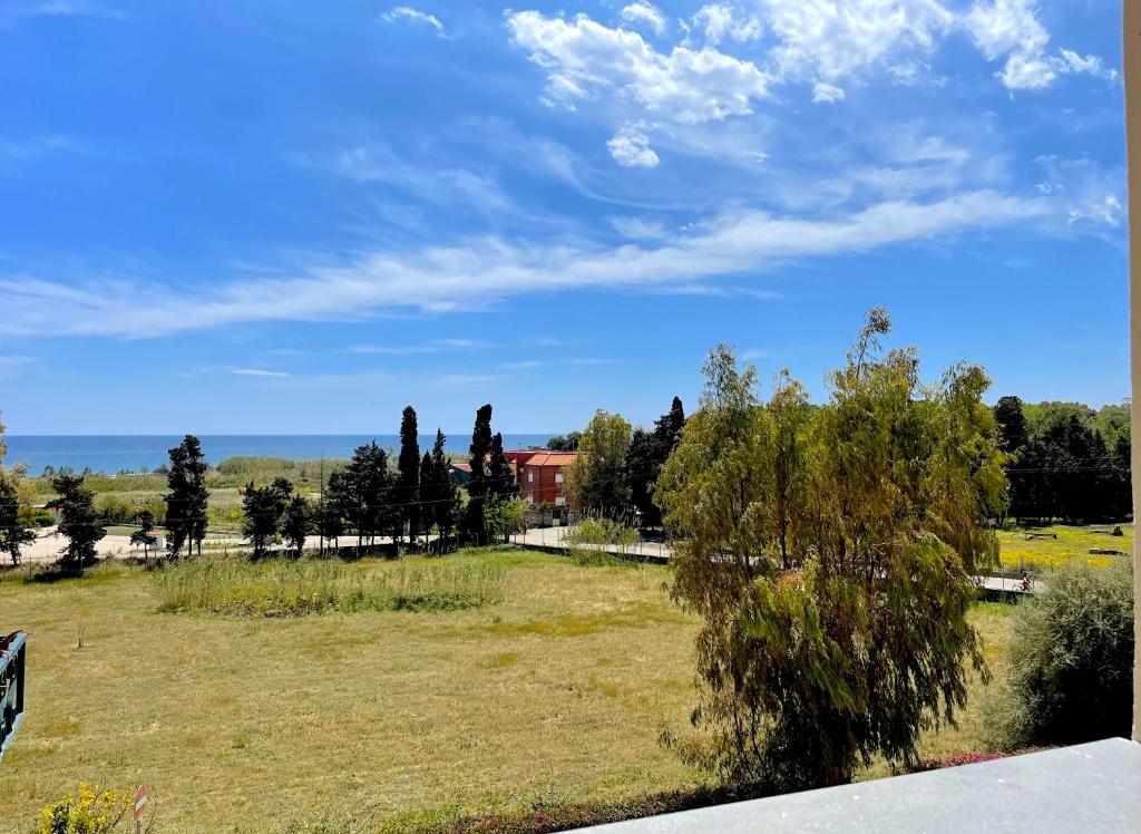 pole trawy z budynkiem w tle w obiekcie Taormina & Sea View Apartment w mieście Giardini Naxos