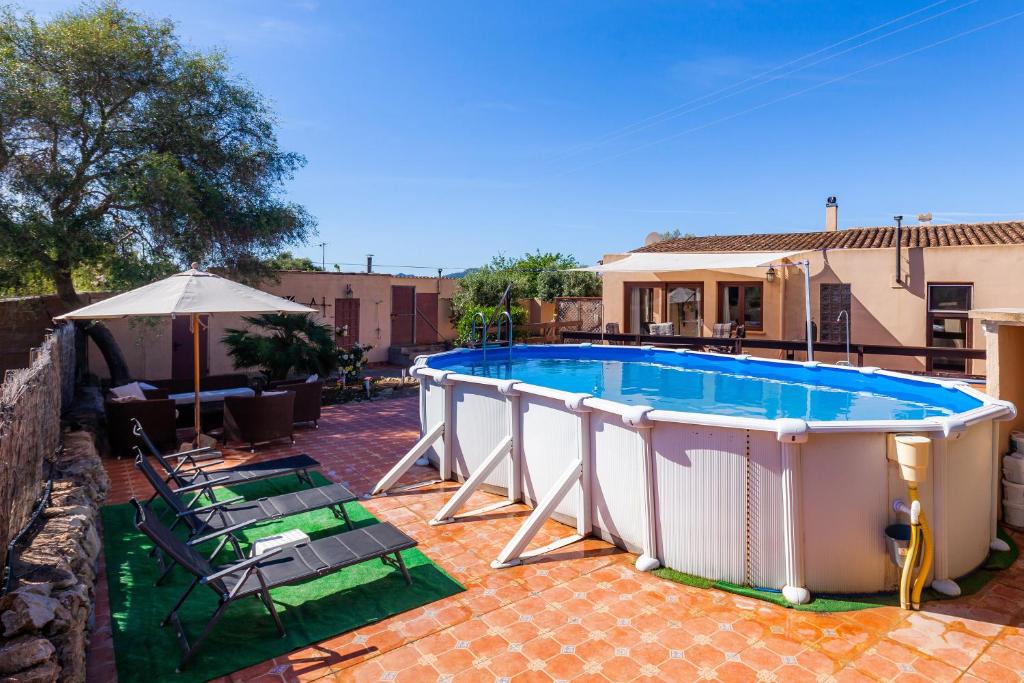 a large swimming pool with chairs and an umbrella at Apartment Tina Capdepera in Capdepera