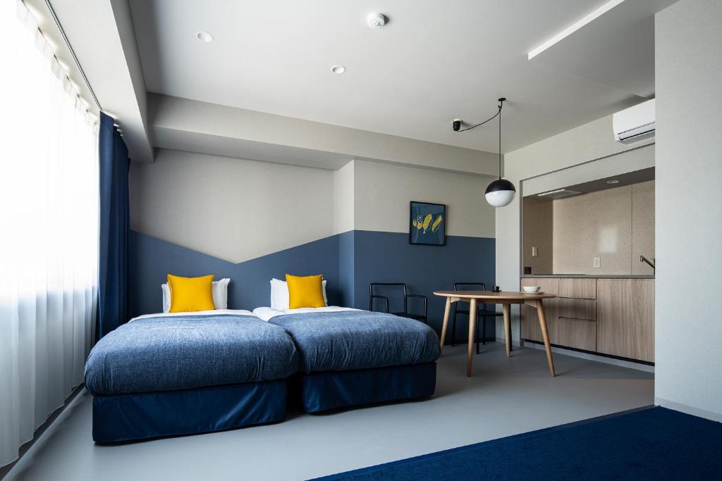 1 dormitorio con 1 cama con almohadas azules y amarillas en Section L Tsukiji, en Tokio