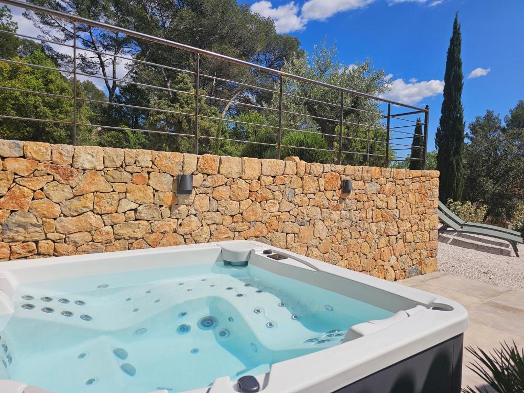 bañera de hidromasaje frente a una pared de piedra en Suite Sieste en Provence, en Entrecasteaux