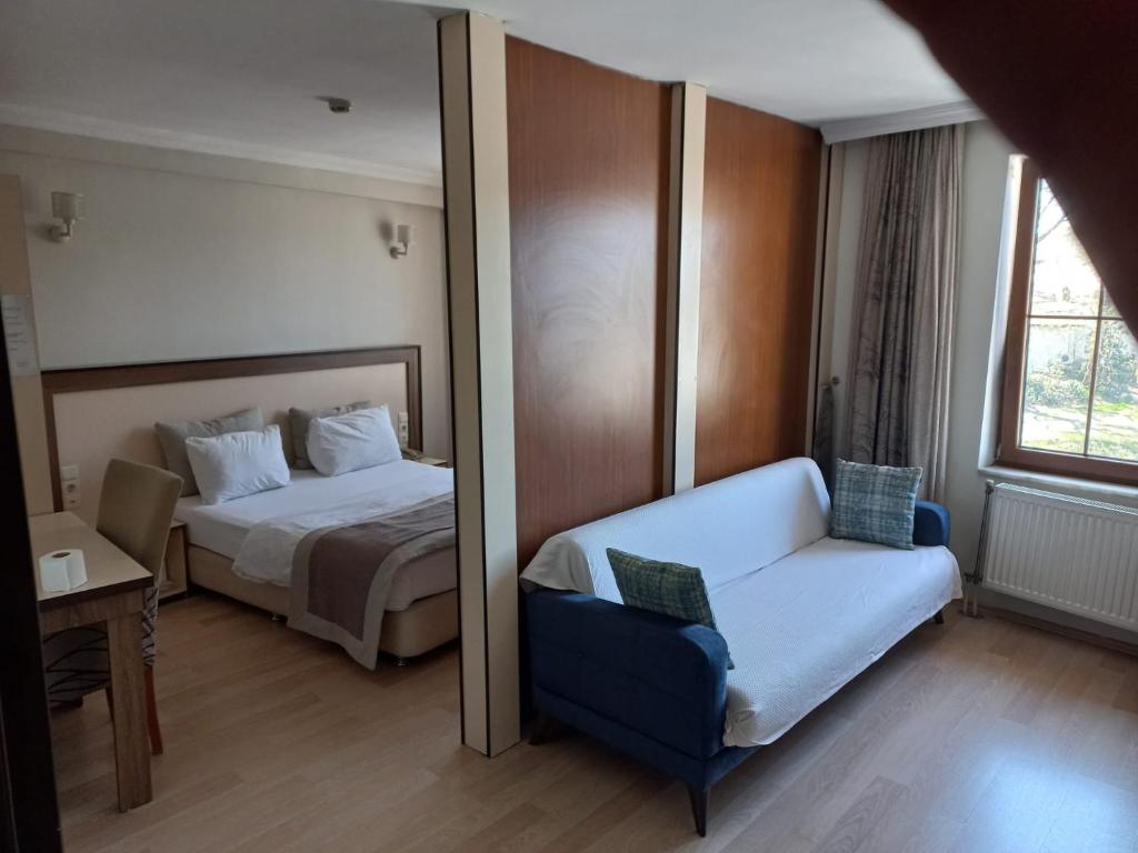 バルトゥンにあるKemer Otelのベッドと鏡が備わるホテルルーム