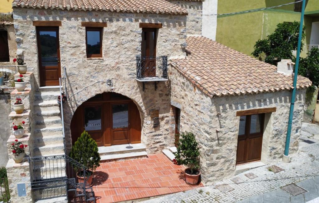 a stone house with a door and a balcony at La Corte Dei Baroni in Loceri
