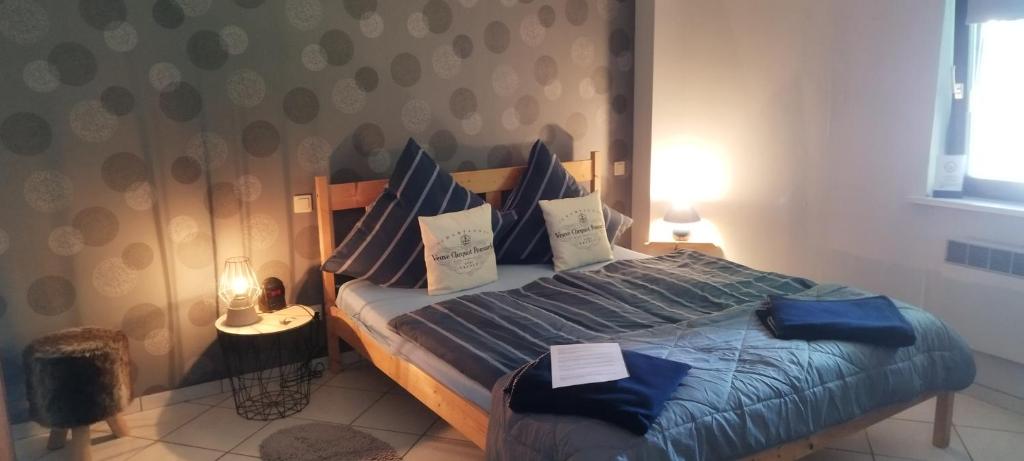 Schlafzimmer mit einem Bett mit blauer Bettwäsche und Kissen in der Unterkunft Pension Deerkemer Kuh in Dorn-Dürkheim