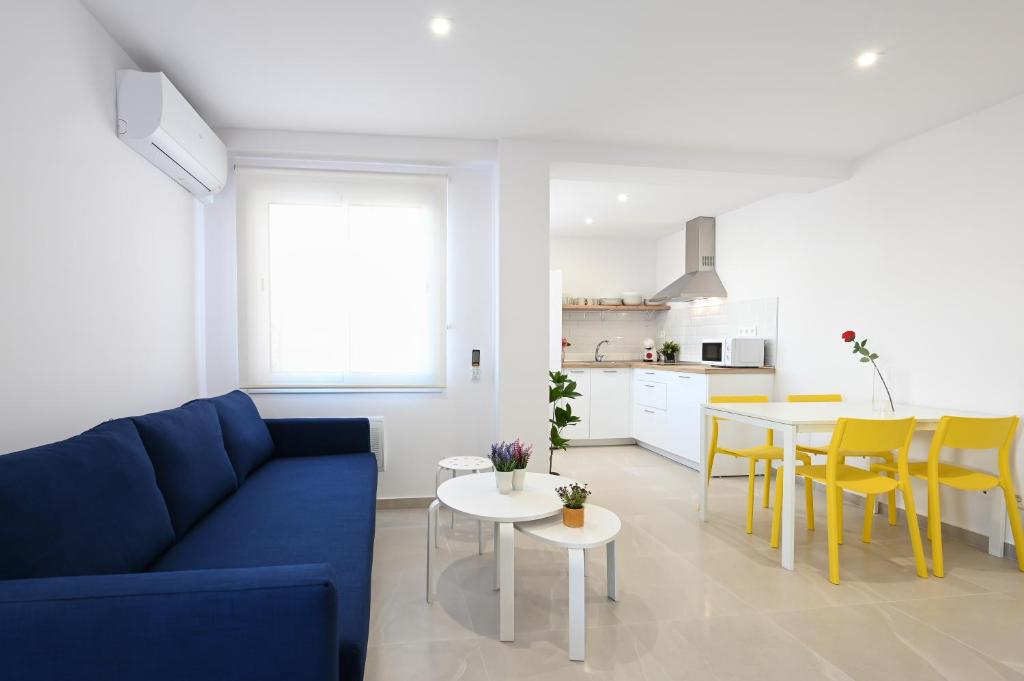 Una sala de estar con un sofá azul y una mesa. en New 2 bedroom beach and city center - Ruiz Vertedor by 10ToSea, en Fuengirola