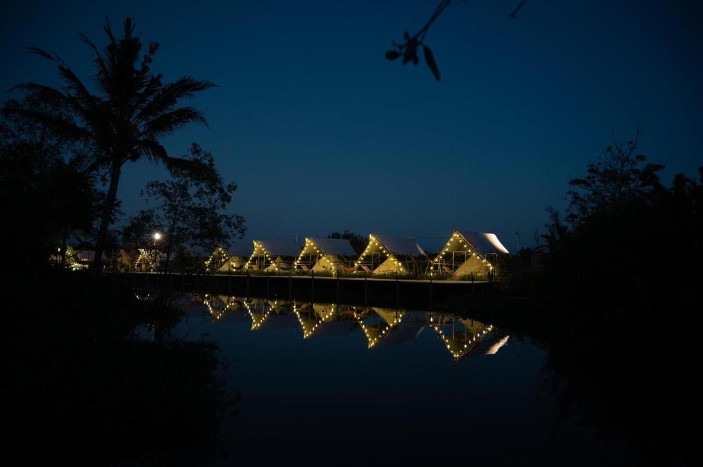 una casa con luces reflejadas en el agua por la noche en Ann Village, en Cái Răng