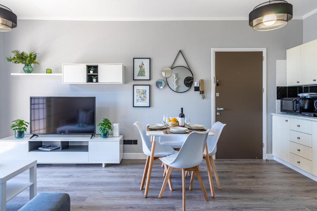 a kitchen and dining room with a table and chairs at Peale's 2-Bedroom Apartment in Mackenzie in Larnaka