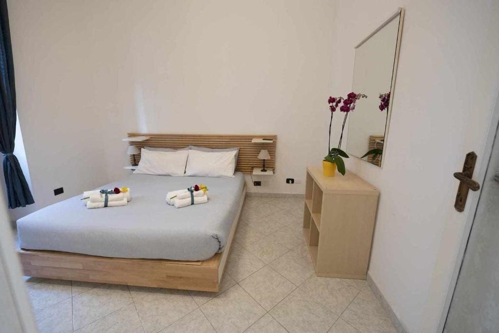 een slaapkamer met een bed met twee handdoeken erop bij Alloggio in palazzina stile Liberty Fronte Mare in Nettuno