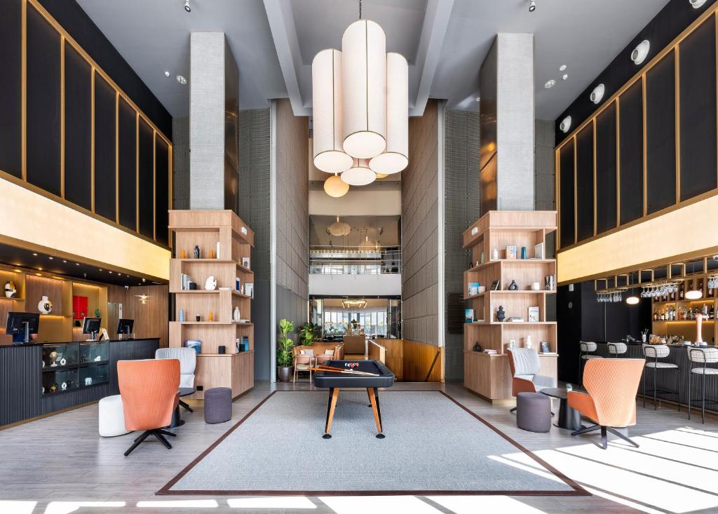 a lobby of a hotel with chairs and a table at Hotel Barcelona Condal Mar Affiliated by Meliá in Barcelona
