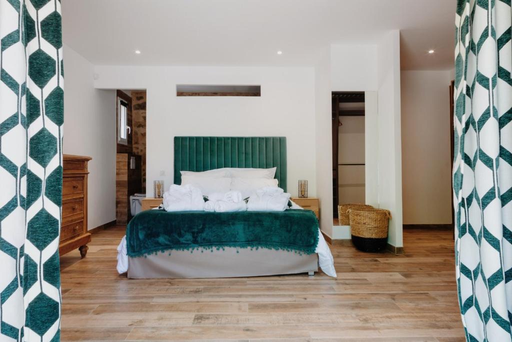 1 dormitorio con 1 cama con manta verde y blanca en Villa U Laziu, en Corbara