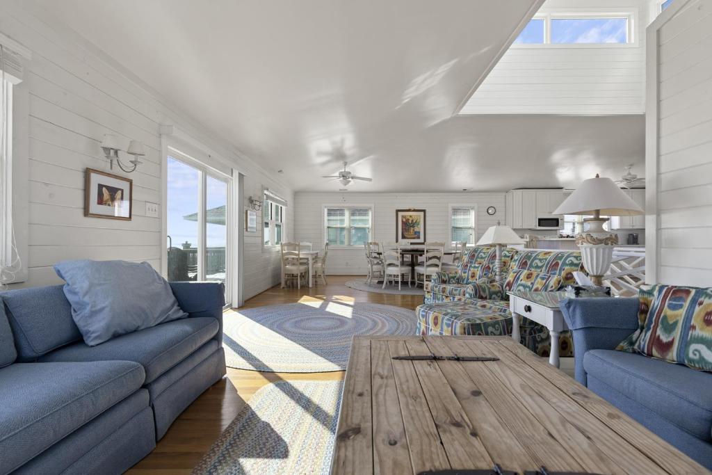 a living room with blue couches and a table at Suncatcher home in Atlantic Beach