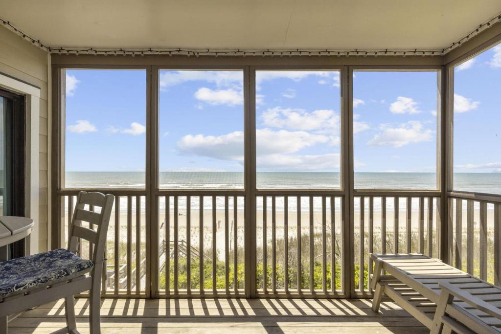 un porche cubierto con vistas al océano en Point Prospect Shores condo, en Pine Knoll Shores