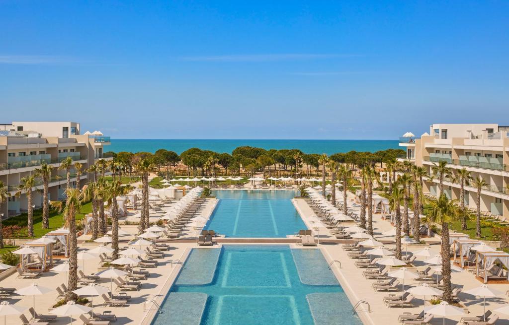 an aerial view of a resort with a swimming pool and palm trees at Meliá Durrës Albania in Durrës