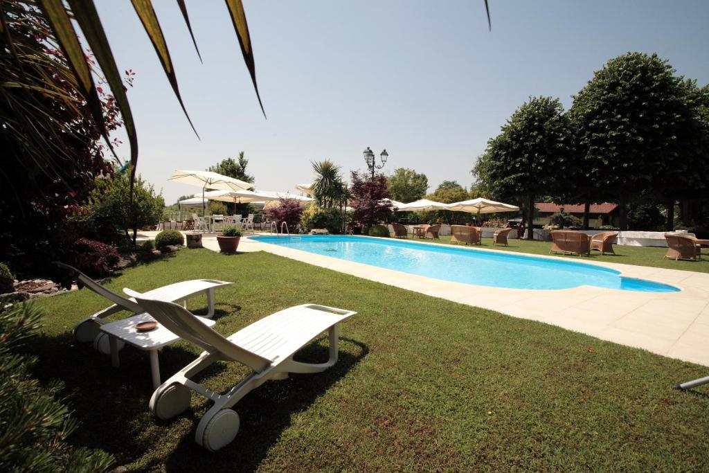 a swimming pool with two lounge chairs next to it at Villa Casa Country in Bovolenta