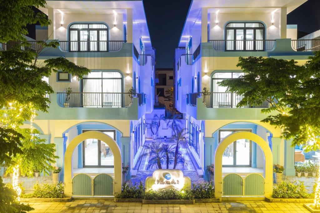 a blue building with a fountain in front of it at Villa FLC Sầm Sơn BT VIP Phong Cách Địa Trung Hải in Sầm Sơn