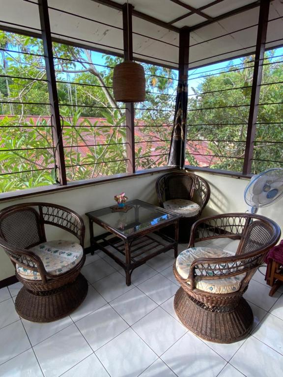 a screened in porch with two chairs and a table at Homestay Galpera Papua in Jayapura