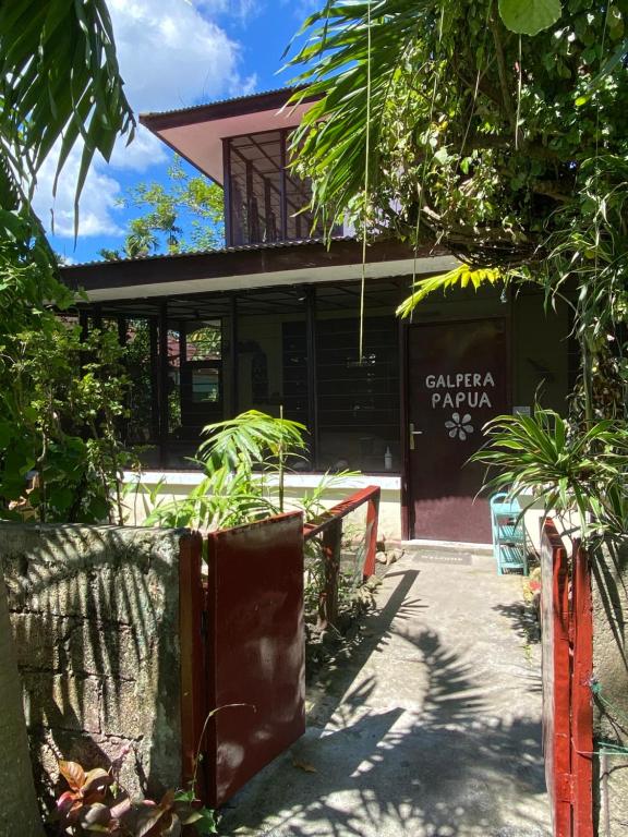 a building with a table and chairs in front of it at Homestay Galpera Papua in Jayapura