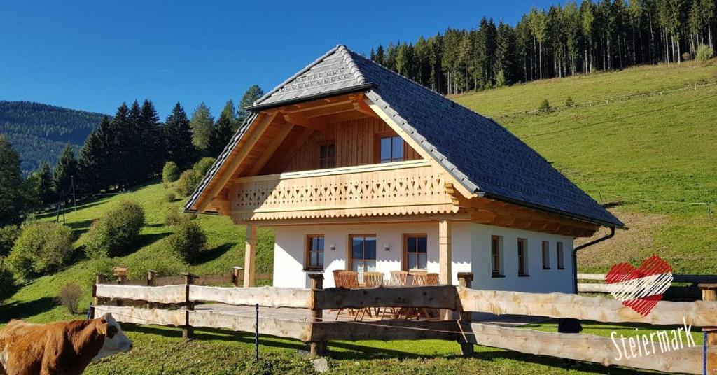 una piccola casa con un tetto nero su una collina di Premiumalmhütte Wiedhupf a Peterdorf