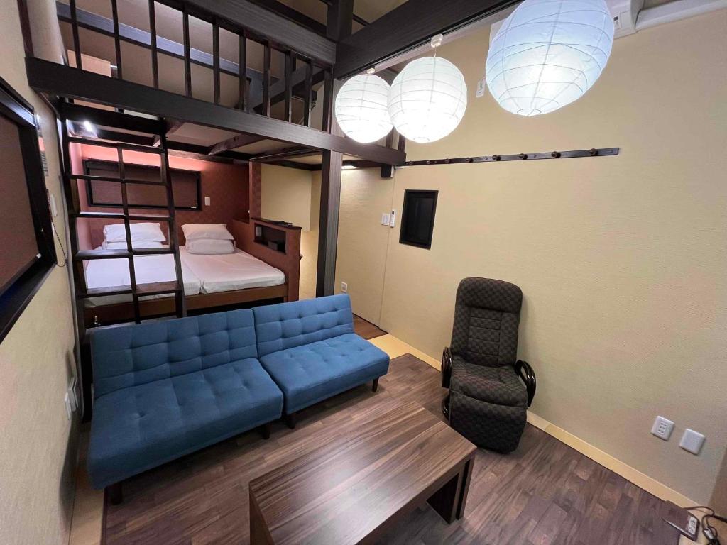Japanese Modern House in Shinagawa في طوكيو: غرفة معيشة مع أريكة زرقاء وسرير