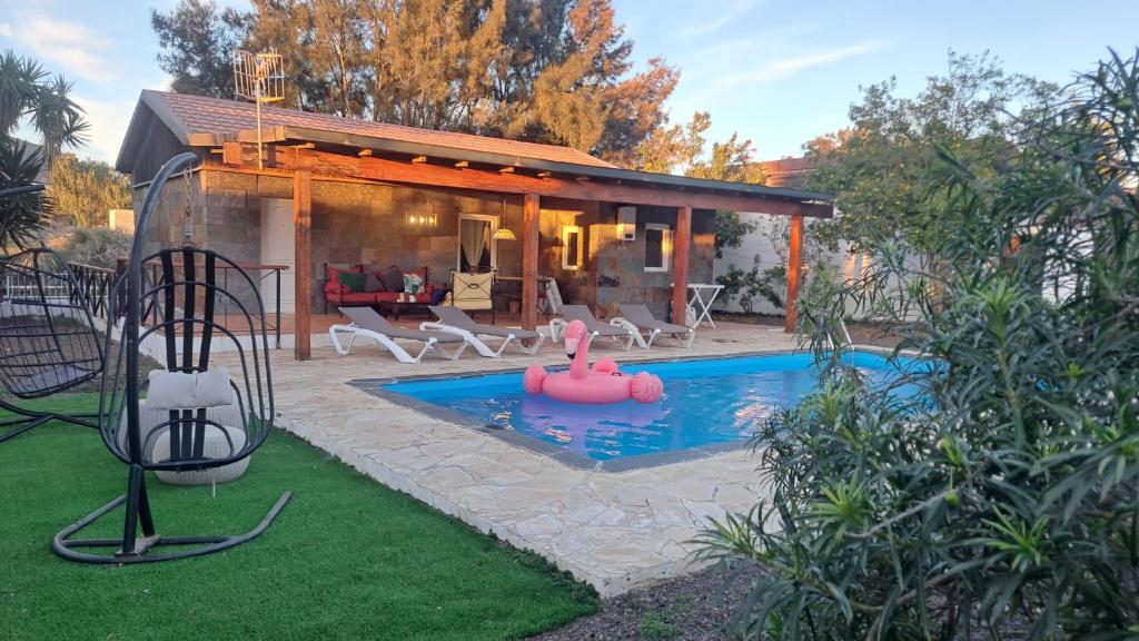ラ・オリーバにあるCasa Helenaのピンクの浮き輪が浮かぶスイミングプール付きの家