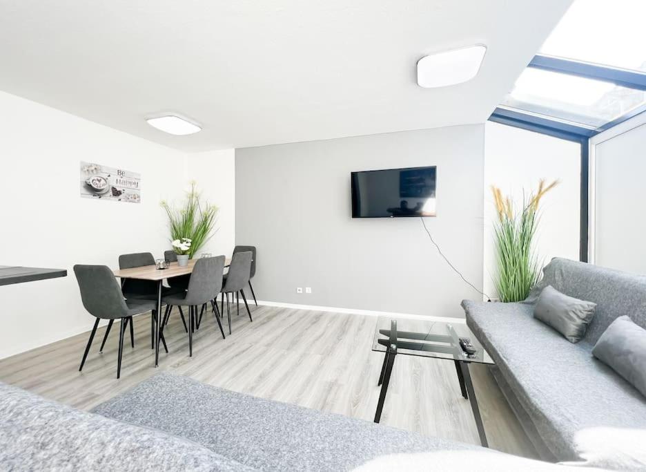 uma sala de estar branca com um sofá e uma mesa em Schickes Apartment in City Lage B7 em Karlsruhe