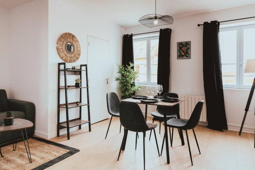 a living room with a dining room table and chairs at NEPTUNE - Appartement Moderne & élégant in Saint-Étienne
