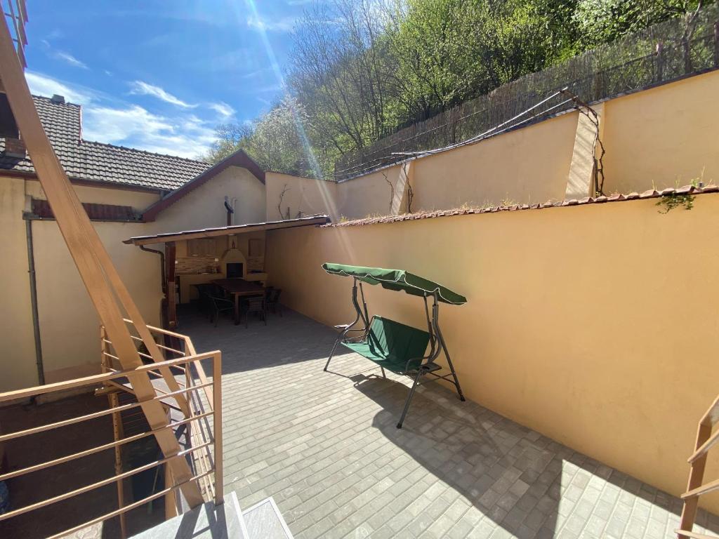eine Terrasse mit einem Tisch und einer Hängematte an der Wand in der Unterkunft Casa Bașu in Băile Herculane
