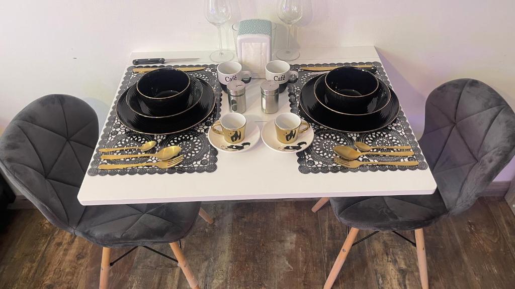 a table with two chairs with hats on top at Le cocon du Nil jolie studio in Douai